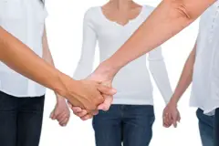 Women standing and holding hands in a circle